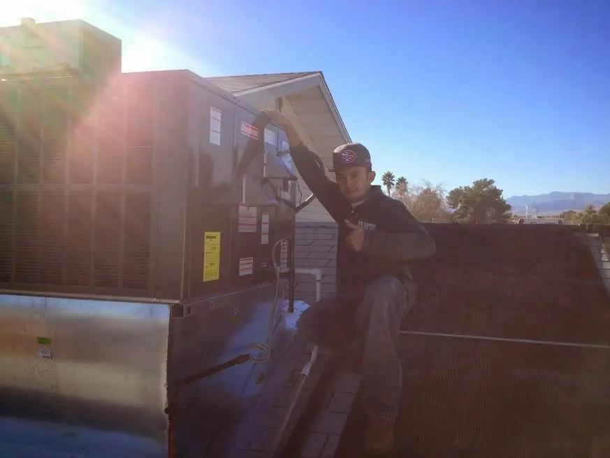 HVAC technician performing AC Tune-Up on a rooftop unit in Charleston